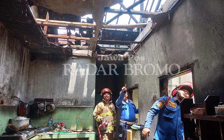 Petugas Damkar saat melakukan pembasahan di rumah Sulis yang dilalap api, Senin (10/3). (Inneke Agustin/ Radar Bromo)