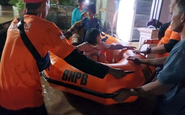 Petugas saat mengevakuasi anak-anak yang rumahnya terendam banjir di Krejengan. (Agus Faiz Musleh/ Radar Bromo)