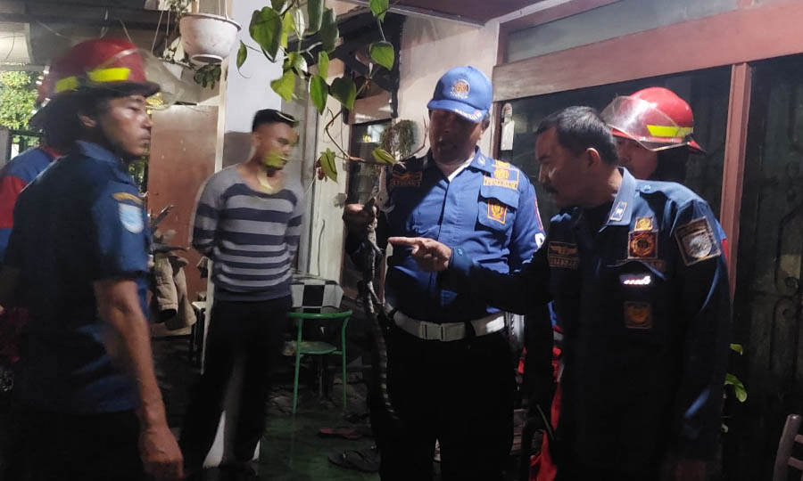 EVAKUASI: Tim Damkar Satpol PP Kota Probolinggo mengevakuasi biawak dari rumah Fafan, warga Kelurahan Sukabumi, Kecamatan Mayangan, Selasa (11/3) malam.