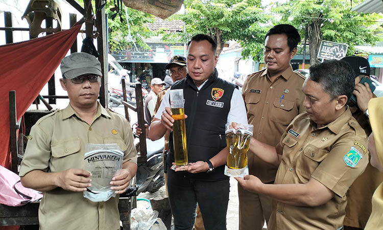 UKUR: Tim Satgas Pangan Polres Pasuruan bersama Disperindag Kabupaten Pasuruan saat melakukan pengukuran terhadap minyak subsidi. Petugas mendapati isi minyak dalam kemasan yang tak sesuai takaran.
