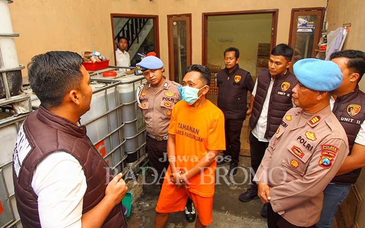 Tersangka Alim saat dimintai keterangan penyidik di rumahnya yang jadi home industry minyak goreng kemasan botol tanpa label, di Pandaan, Rabu (12/3). (Rizal Syatori/ Radar Bromo)