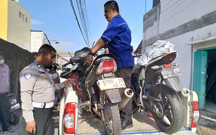 BARANG BUKTI: Polisi saat mengamankan motor Honda Supra X dan Yamaha Vixion yang terlibat tabrakan di Sukorejo, Kabupaten Pasuruan. (Rizal Syatori/ Radar Bromo)
