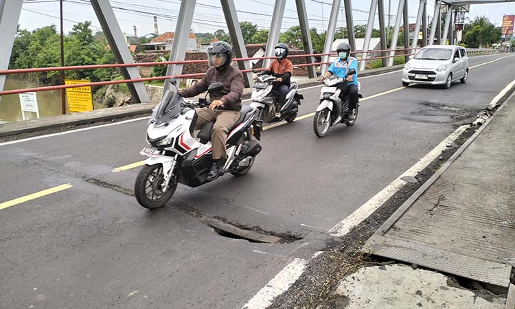 BERLUBANG: Kondisi sisi timur Jembatan Pajarakan di Kecamatan Pajarakan, Kabupaten Probolinggo, berlubang dan bergelombang membahayakan pengguna jalan. (Achmad Arianto/ Radar Bromo)