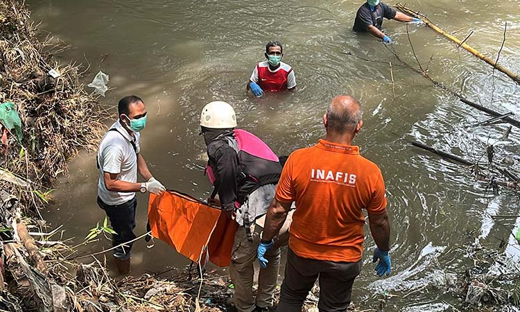 Petugas saat hendak mengevakuasi mayat kakek yang hanyut di sungai Sukorejo, Kabupaten Pasuruan. Jenazahnya ditemukan di Kraton. (Istimewa)