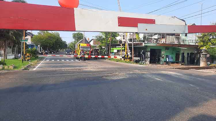 RUSAK: Sejumlah pengendara berhenti sejenak di JPL Pilang, Kecamatan Kademangan. Terlihat kondisi aspal jalan di perlintasan ini rusak.
