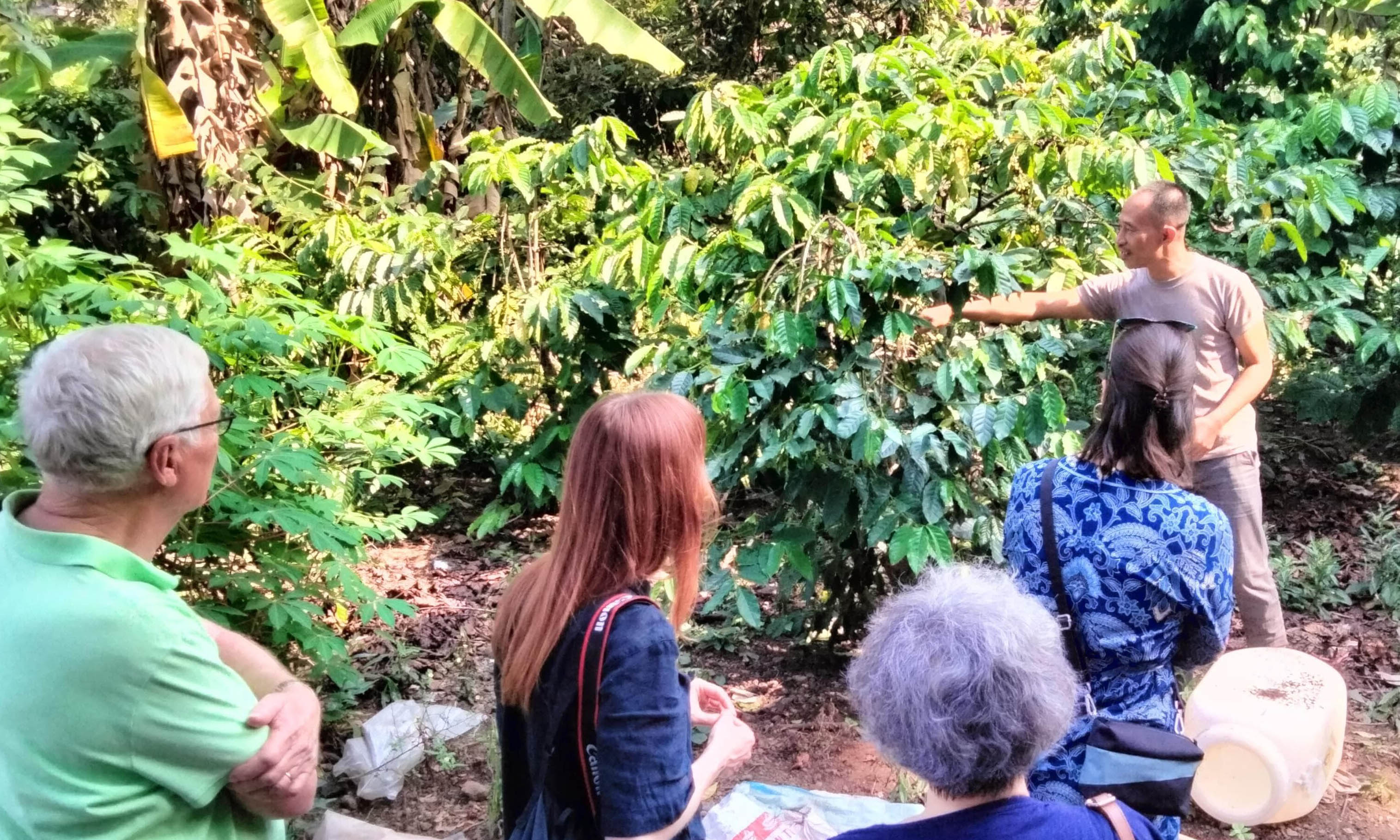 JADI DESTINASI WISATA: Jumali petani kopi asal Desa Dayurejo, saat mendampingi tamu turis mancanegara berkunjung ke kebun kopi miliknya.