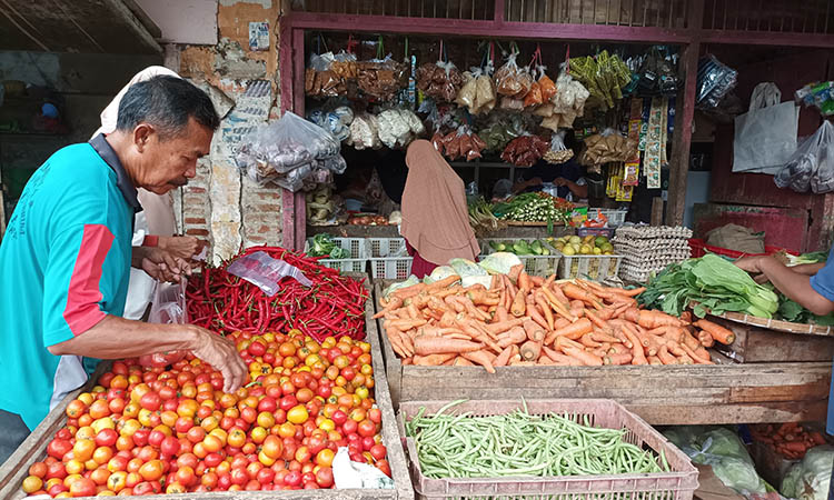 MAHAL: Seorang pedagang di Pasar Semampir saat menata barang dagangannya, tomat hingga cabai. Meski turun, harga cabai di pasaran masih terbilang tinggi.