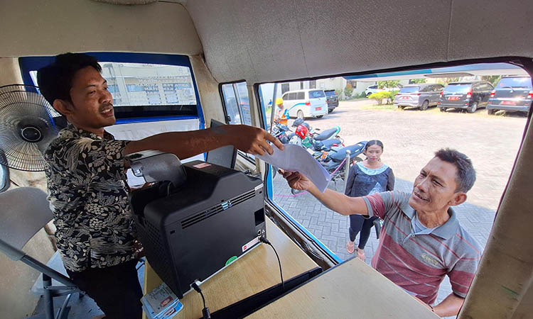 LAYANI: Petugas Dispendukcapil Kabupaten Pasuruan saat memberikan pelayanan kepada warga yang mengurus adminduk. Selama lebaran, layanan adminduk tetap buka.