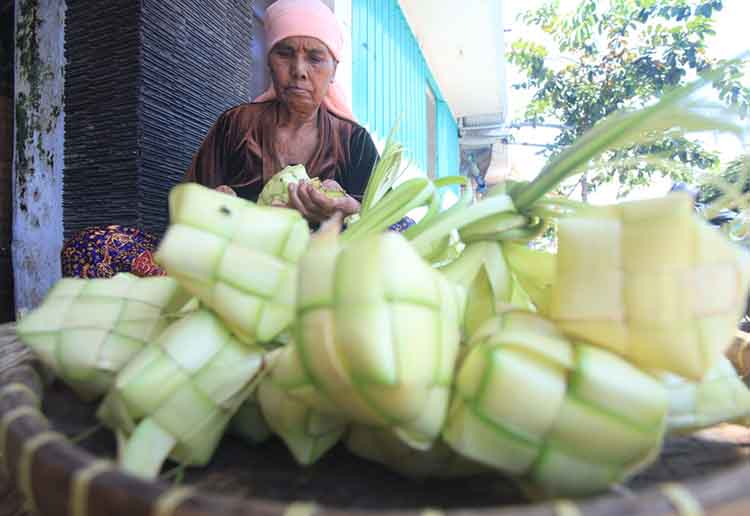 MAKIN LARIS: Seorang pedagang selongsong ketupat di Pasar Baru Kota Probolinggo menunggu pembeli.