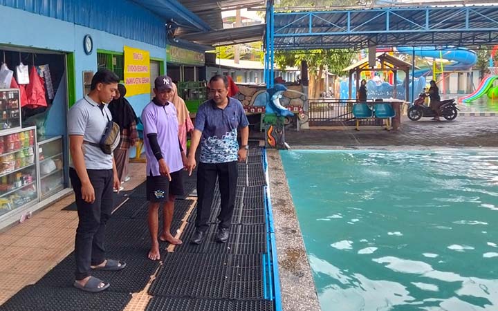 CEK LOKASI: Petugas menunjukkan lokasi  AAZ ditemukan tenggelam di kolam renang Sebani, Pandaan. (Polsek Pandaan for Radar Bromo)