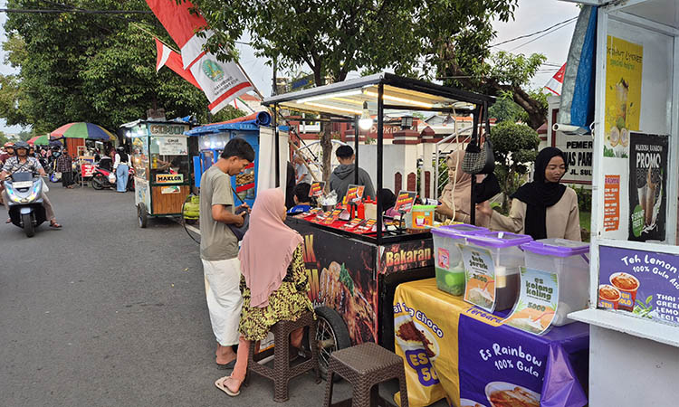 MENGGELIAT: Deretan PKL yang berjualan di Jalan Sultan Agung Kota Pasuruan. Mereka mendorong agar pemanfaatan QRIS bisa direalisasikan dalam metode pembayaran.