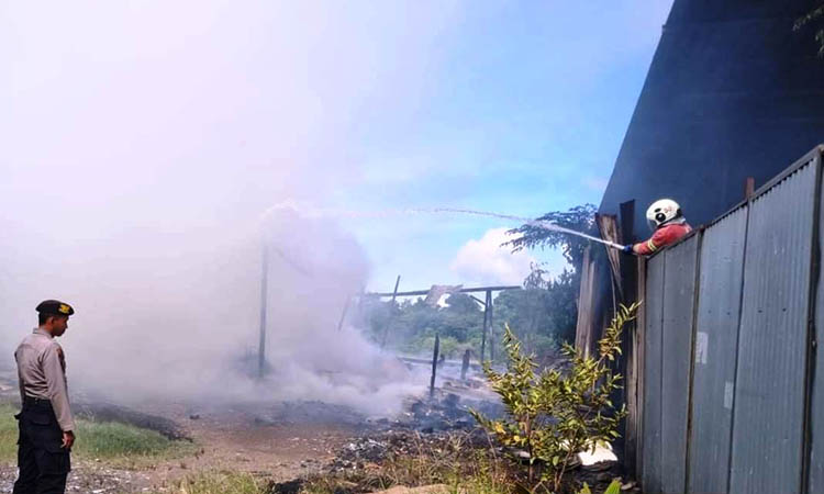 PADAMKAN: Tim damkar saat berusaha untuk memadamkan api yang membakar eks gudang rongsokan milik Mulyadi, warga Desa Mojoparon, Kecamatan Rembang, Kabupaten Pasuruan.