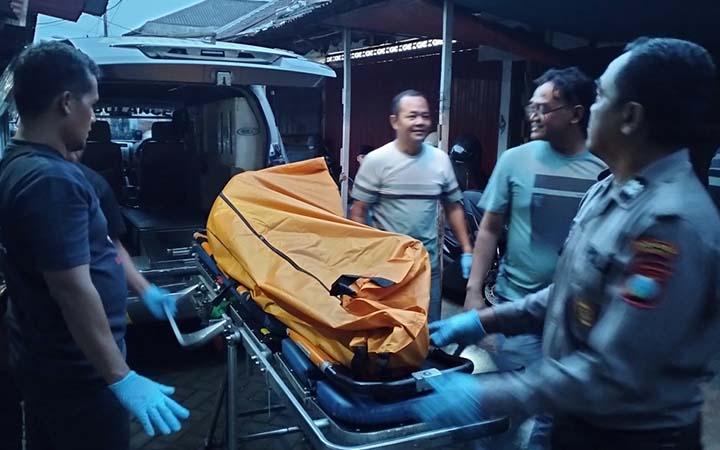 DIDUGA SAKIT: Petugas saat mengevakuasi jenazah Subaweh, pengamen asal Jember yang ditemukan tergeletak di Pasar Senggol Pandaan. (Rizal Syatori/ Radar Bromo)