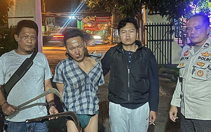DIAMANKAN: Zainal Abidin, 51, warga Dusun Asem Jajar, Desa Randugong, Kecamatan Kejayan, saat diamankan petugas kepolisian. Ia ditangkap karena membawa sajam jenis celurit. (Istimewa)