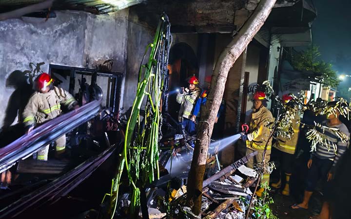 PEMBASAHAN: Tim Damkar saat melakukan pembasahan di rumah nenek Darmo di Triwung Kidul yang terbakar, Selasa dinihari (15/4). (Istimewa)