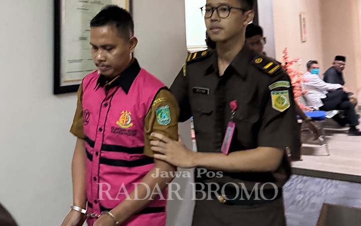 DIBERHENTIKAN SEMENTARA: Nurkamto, operator Dapodik di Dinas Pendidikan dan Kebudayaan (Disdikbud) Kabupaten Pasuruan saat digelandang penyidik kejari. (M Busthomi/ Radar Bromo)