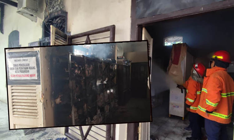 PEMBASAHAN: Personel Damkar melakukan pembasahan di salah satu sudut ruang arsip kantor Dinas PUPR Kota Pasuruan, Jumat (18/4) siang. Inset, Arsip di rak y