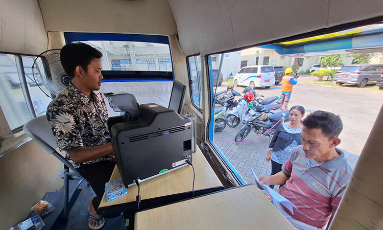 LAYANI: Petugas Dispendukcapil Kabupaten Pasuruan saat melayani warga yang mengajukan pengurusan adminduk di layanan walk thru.