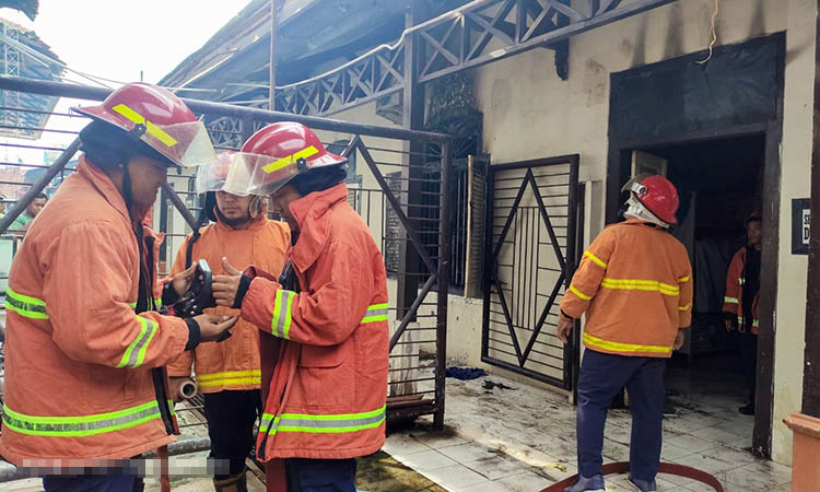 PADAMKAN: Petugas Damkar saat berusaha memadamkan api di gudang arsip Dinas PUPR beberapa waktu lalu. Api diduga, dari AC yang ada di dalam gudang.
