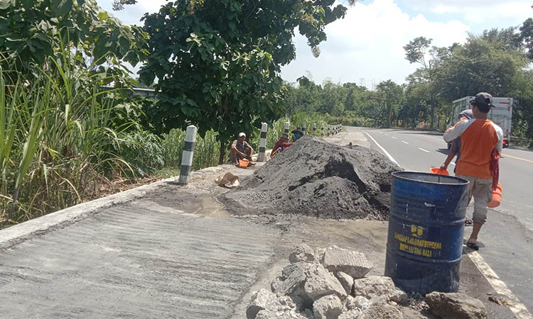 LEBIH KUAT: Pekerja sedang melakukan perbaikan TPT di Jalan raya Leces. Bangunan ini sempat ambrol setelah digunakan parkir truk bertonase berat.