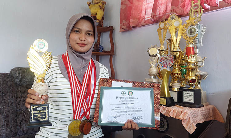TERBAIK: Uswatun Hasanah dengan trofi Piala Pangdivif 2 Kostrad Jatim.