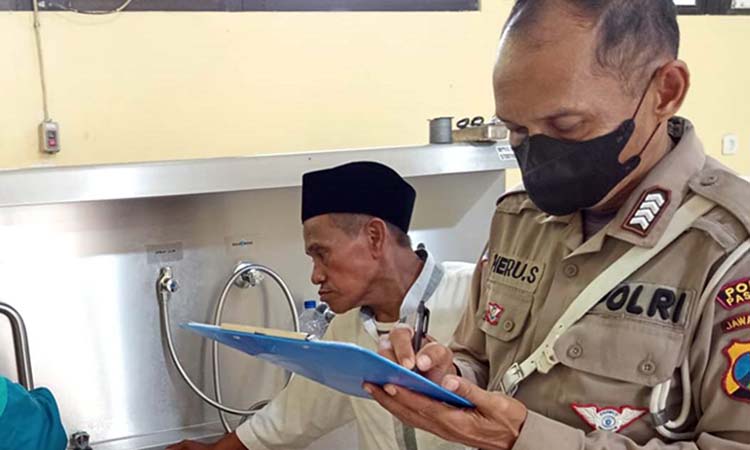 Petugas Unit Laka Satlantas Polsek Gempol saat mengantar korban ke kamar jenazah.