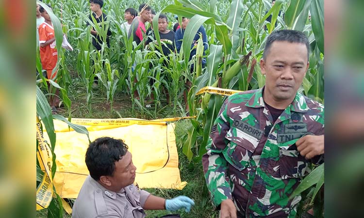 EVAKUASI: Anggota Polsek Dringu bersama warga saat mengevakuasi korban yang ditemukan di sebuah ladang jagung pada Minggu (27/4) sore.