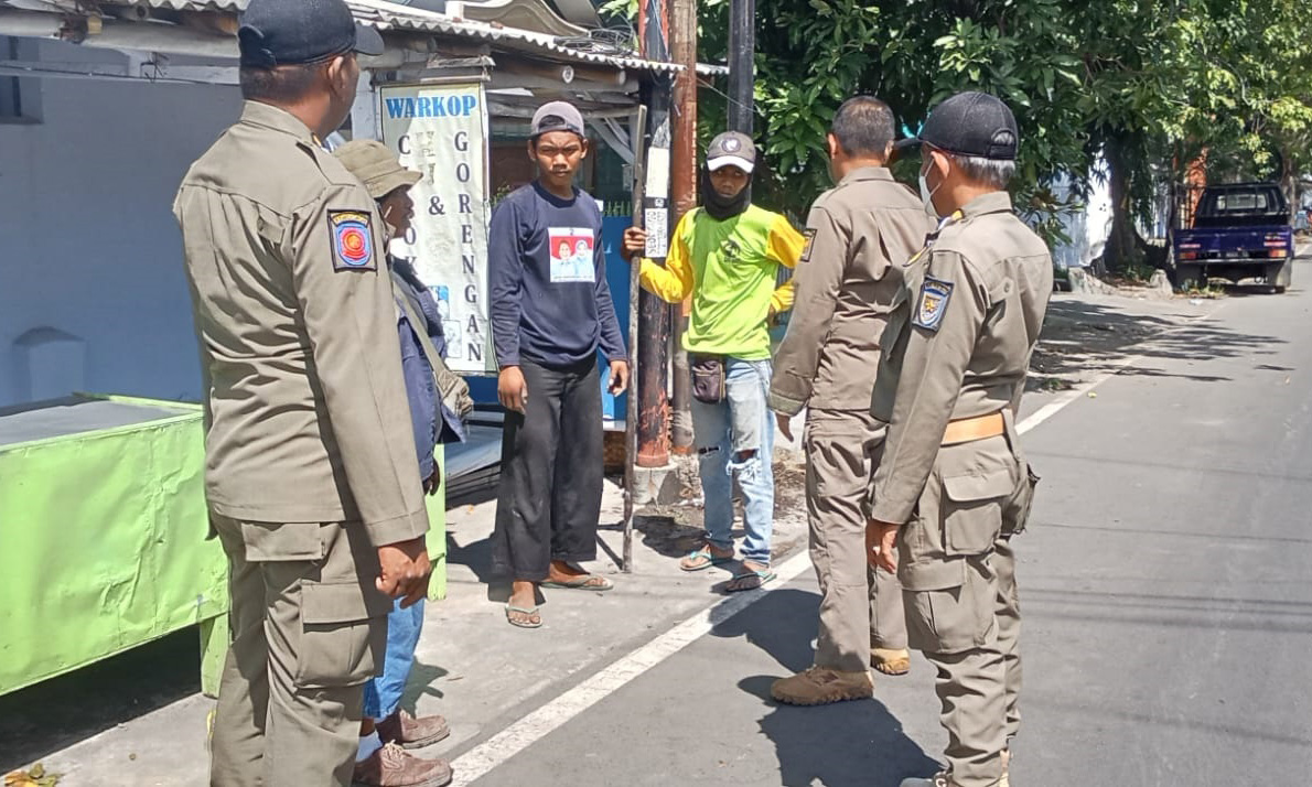 DIHENTIKAN: Anggota Satpol PP Kota Probolinggo menghentikan pemasangan tiang internet di Kelurahan/Kecamatan Mayangan, Senin (28/4).