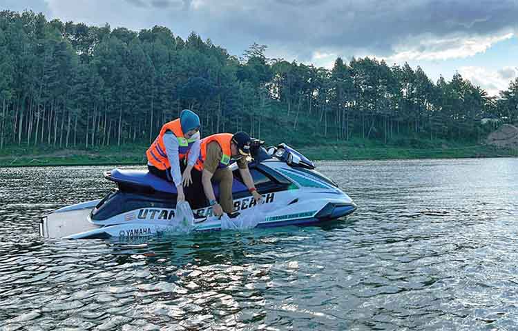 SEBAR BENIH: Bupati Probolingo dr. Mohammad Haris bersama Ketua TP PKK Ning Marisa Juwita Sari menebar benih ikan dengan mengendarai motorboat.