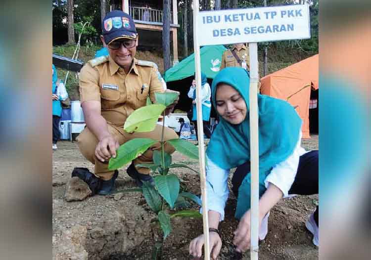 PEDULI: Ketua TP PKK Desa Segaran Yeni Oktavia didampingi Kepala Desa Segaran Budi Utomo menanam pohon di pinggir Ranu Segaran.