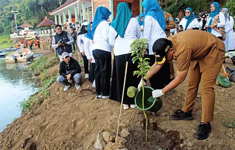TANAM POHON: Bupati Probolinggo dr. Mohammad Haris menanam pohon di pinggir Ranu Segaran.