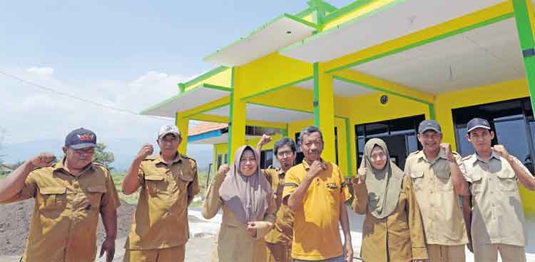 SINERGI: Kepala Desa Bucor Kulon Abd Sukur (kaus kuning tengah) berfoto bersama perangkat desa di Gedung Serbaguna.