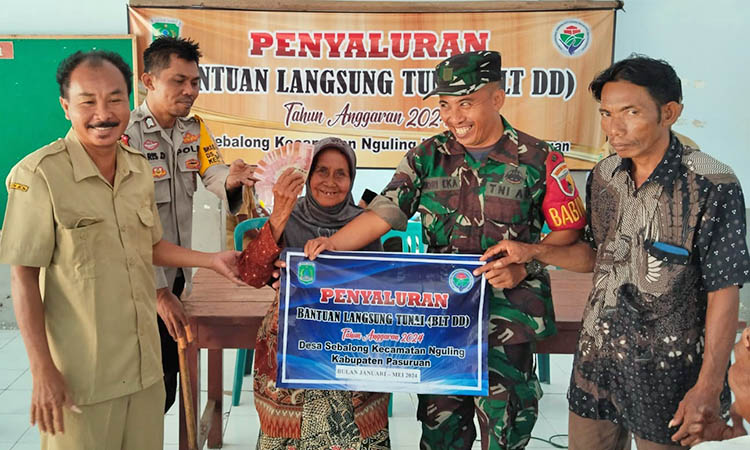 BANTUAN: Kepala Desa Sebalong Samsuri Agung Laksono memberikan BLT-DD kepada masyarakat penerima manfaat.