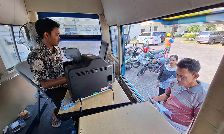 LAYANI: Petugas Dispendukcapil Kabupaten Pasuruan saat melayani pemohon adminduk melalui layanan walk thru.
