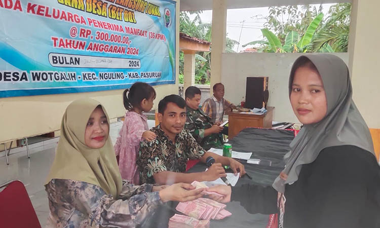 RINGANKAN BEBAN: Kepala Desa Wotgalih Rini Kusmiyati memberikan BLT DD kepada keluarga penerima manfaat.