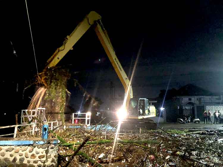 PENUH SAMPAH: Sampah yang menumpuk di Dam Kelep, Kecamatan Kademangan, dibersihkan menggunakan excavator long hand, Senin (12/5) malam.