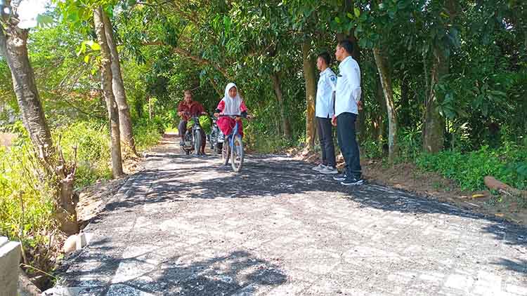 LEBIH NYAMAN: Seorang anak pulang sekolah melintasi jalan paving di RT 10/RW 3, Dusun Terong, yang baru selesai dibangun.