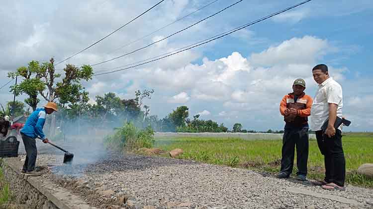 CEK LANGSUNG: Kepala Desa Sumberan Hasyim Said Mansur (kanan) mengecek pengerjaan pengaspalan jalan di RT 6/RW 1, Dusun Krajan.