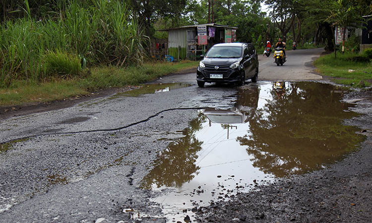 MENGGENANG: Jalan Banyu Biru-Ngopak yang kondisinya memprihatinkan. Kerusakan itu, membuat jalan tampak seperti kubangan air.