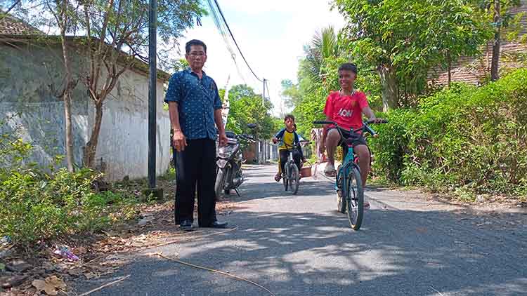 MULUS: Sekretaris Desa Alastengah Samsul Aripin mengecek jalan aspal di RT 8/RW 3, Dusun Dauh, yang sudah rampung dibangun.