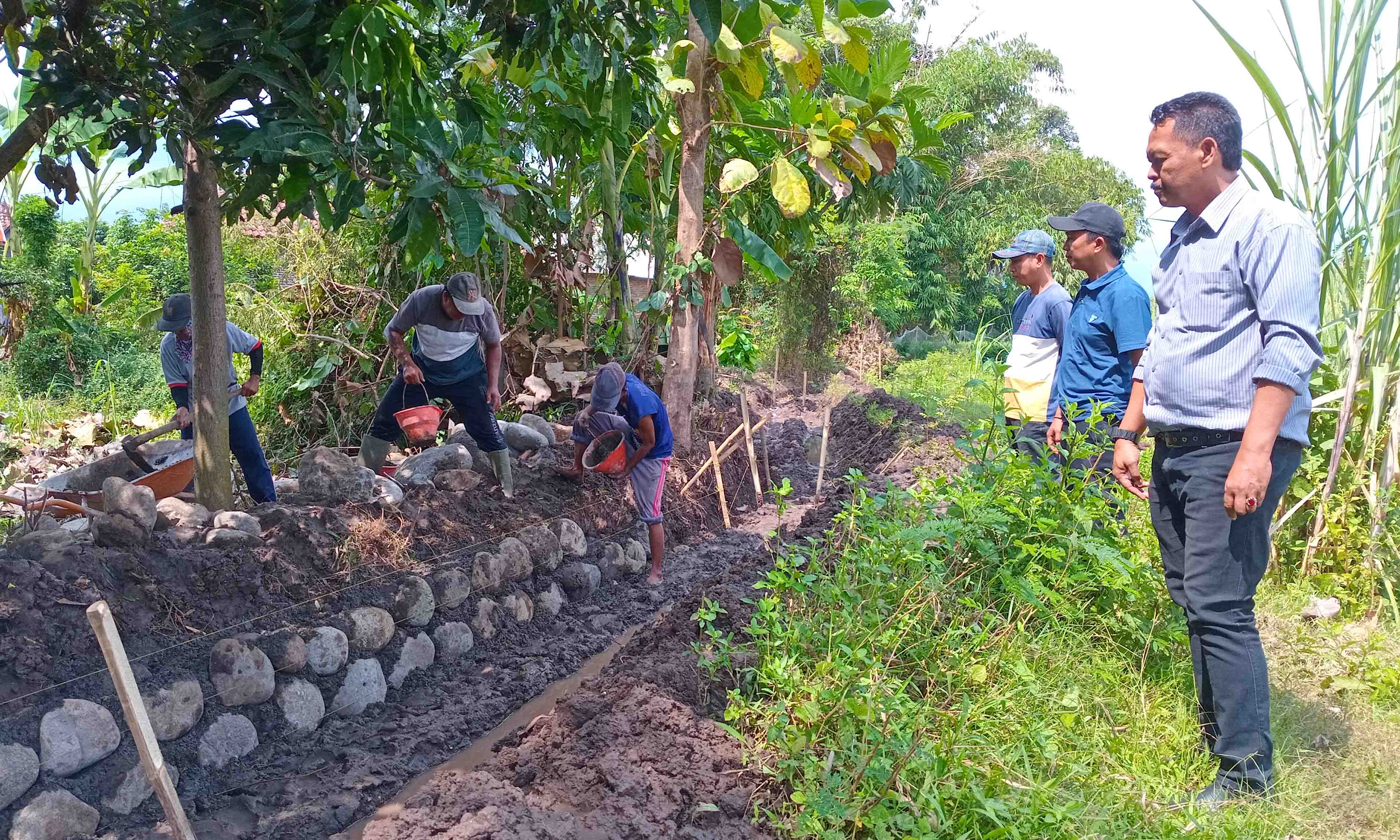 LEBIH KUAT: Sekretaris Desa Besuk Kidul Kusyanto (kanan) mengecek pembangunan irigasi di RT 10/RW 3, Dusun Tengah.