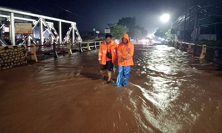 MENGGENANG: Luberan air Sungai Petung yang memicu kemacetan jalan. Pengalihan arus pun dilakukan, untuk mencegah hal tak diinginkan.