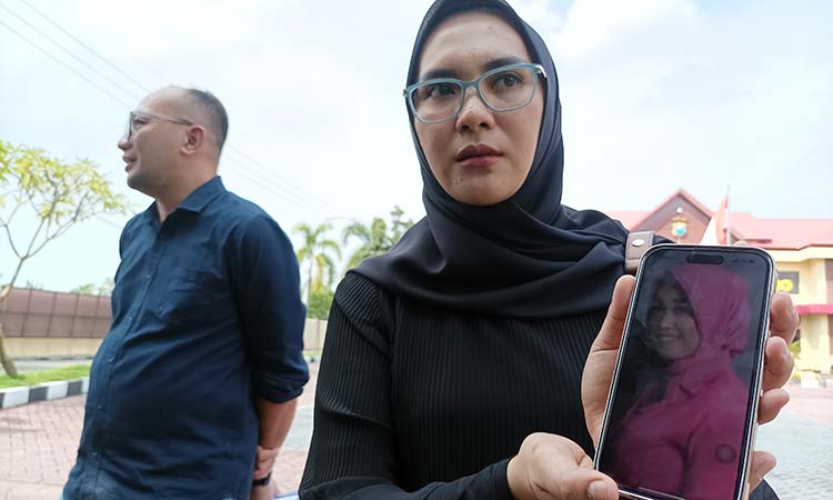 LAPOR POLISI: Melinda Ulifatus Sholehah menunjukkan foto teman lamanya yang dilaporkan polisi saat di Polres Probolinggo. (Agus Faiz Musleh/ Radar Bromo)