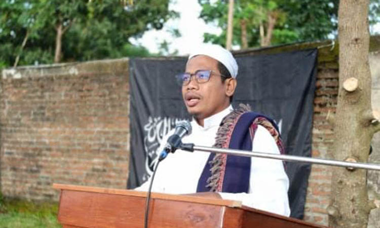 DIPERTANYAKAN: Pengurus Ponpes Al-Ghurobi saat ceramah Idul Fitri dengan background HTI di belakangnya.