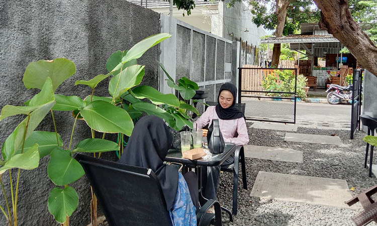 BERSANTAI: Pengunjung tampak bersantai di halaman kafe sembari berbincang ria.