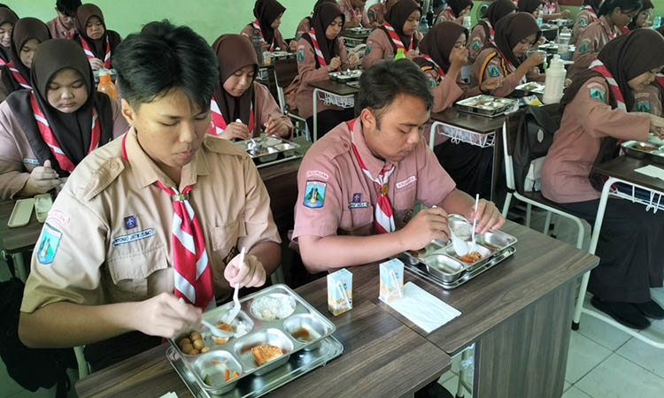 SEHAT: Pelajar kelas XI SMAN 1 Pandaan menikmati makan bergizi gratis di kelas, saat jam istirahat. Saat ini
