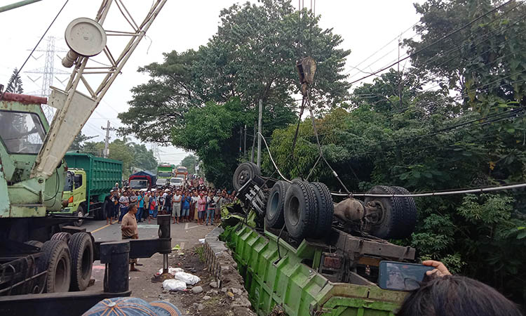 MAKAN WAKTU: Dump truk dievakuasi menggunakan crane.