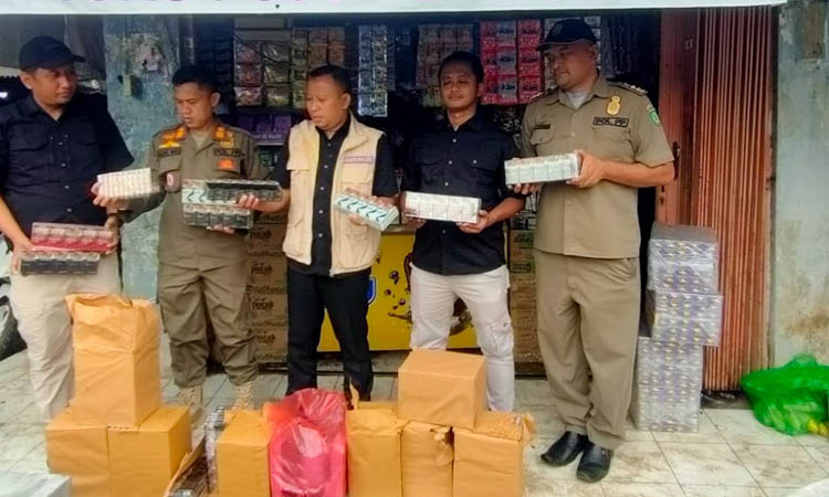 DAPAT BANYAK: Petugas gabungan menunjukkan bungkus rokok illegal yang ditemukan di toko pracangan di Gondangwetan, Selasa (27/5).