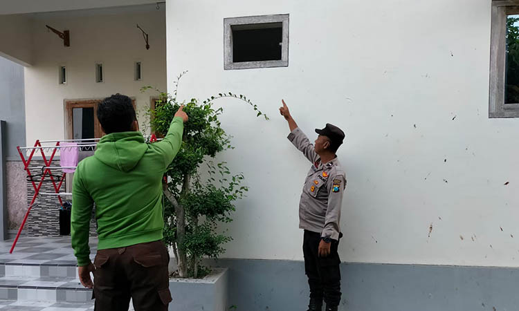 LEWAT SINI: Petugas Polsek Paiton menunjukkan jendela yang dipecah oleh pelaku.