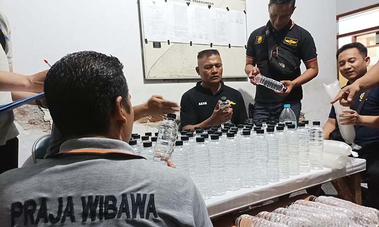 UTAMAKAN PREFENTIF: Jajaran Satpol PP saat mengamankan puluhan botol miras dari toko yang jual miras dekat ponpes di Kraksaan. (Agus Faiz Musleh/ Radar Bromo)